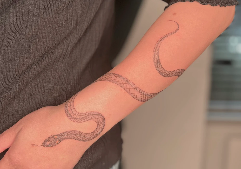 Gyvatės tattoo, apsivyniavusi aplink dilbį ir plaštaką