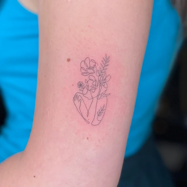 Vienos linijos moters silueto su gėlėmis tattoo ant žasto.