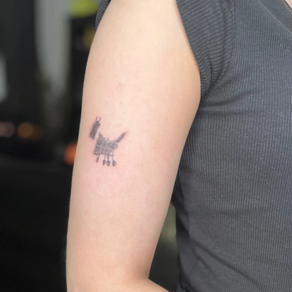 Vaikiško stiliaus šuniuko piešinuko tattoo ant žasto.