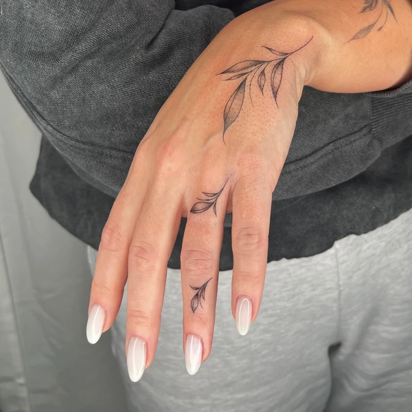 Plonos šakelių ir lapelių tattoo ant rankos ir pirštų