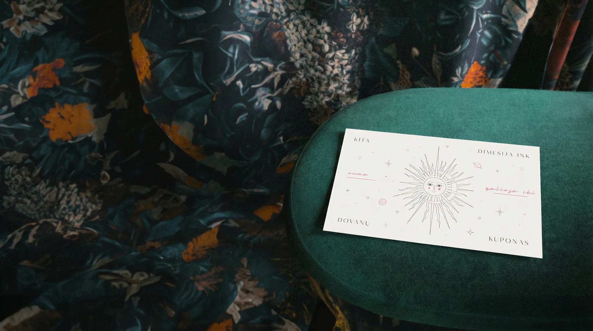 "Kita Dimensija Ink" dovanų kuponas padėtas ant kėdės studijoje