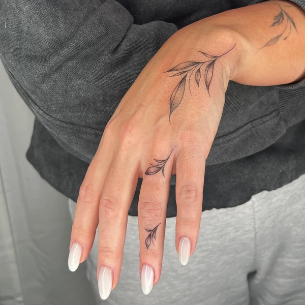 Plonos šakelių ir lapelių tattoo ant rankos ir pirštų