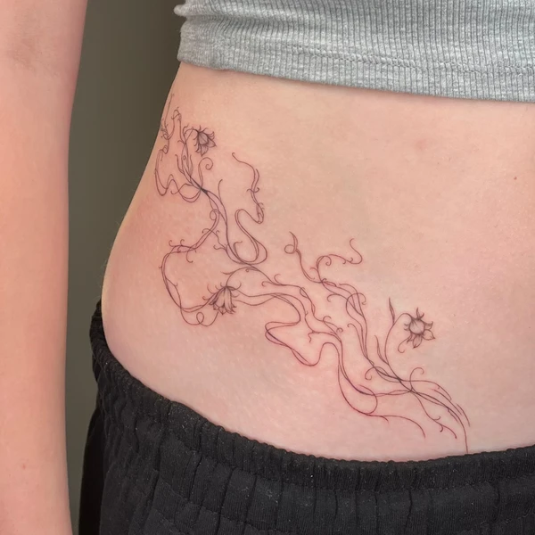 Abstrakti, plona, vingiuota gėlių ir vijoklių linijos tattoo ant šono/juosmens