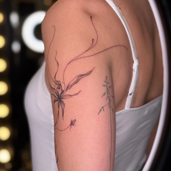 Ilgos plonos linijos su abstrakčia gėle tattoo ant peties