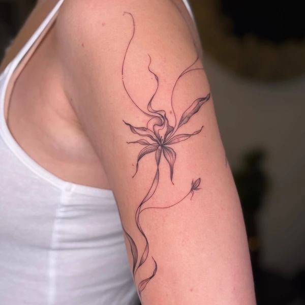 Ilgos plonos linijos su abstrakčia gėle tattoo ant peties